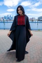 This black jumpsuit features wide pleated legs and is handmade in Palestine