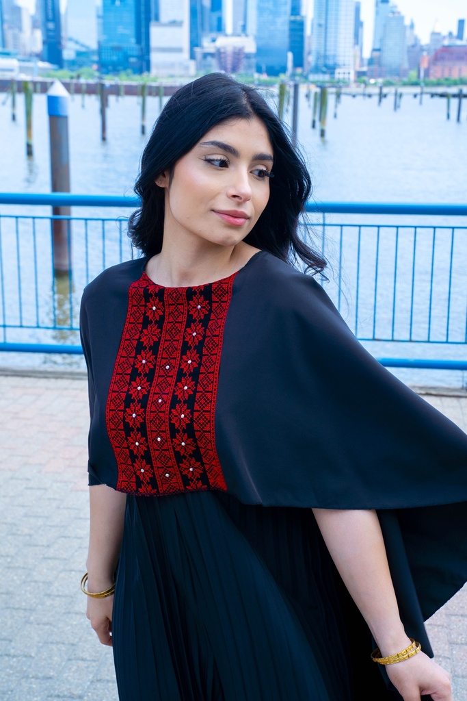 This black jumpsuit features wide pleated legs and is handmade in Palestine