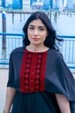 This black jumpsuit features wide pleated legs and is handmade in Palestine